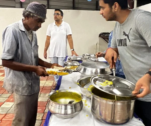 Happy Faces Vadodara volunteer serving food to a man