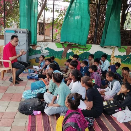 Teacher conducting an outdoor class for children at Happy Faces Vadodara